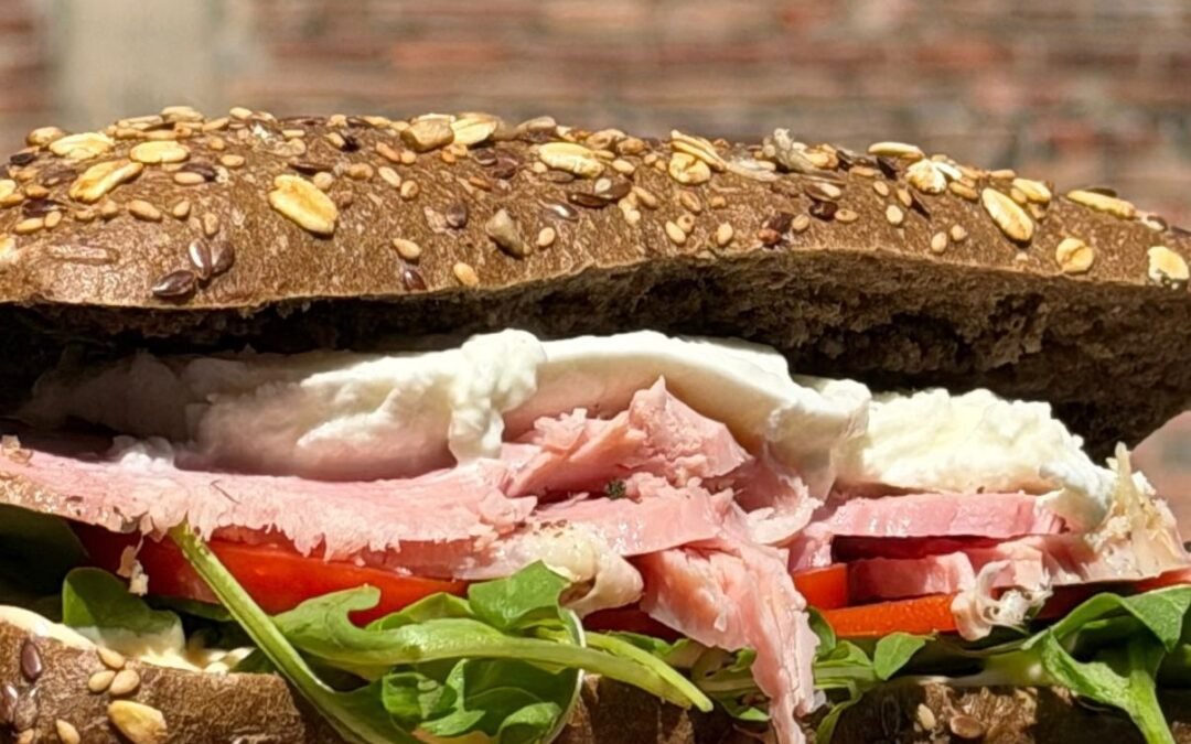 Lo chef Stefano Bona prepara un panino con il prosciutto cotto artigianale per i catering di Posto a Tavola