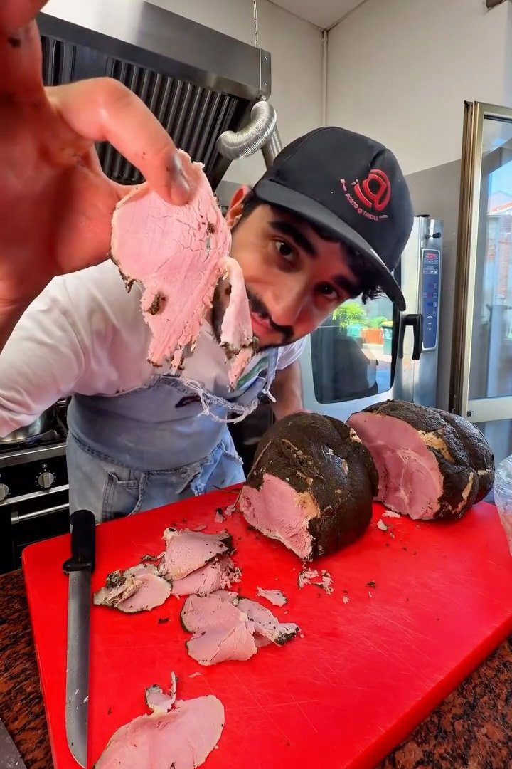 Lo chef Stefano Bona prepara il prosciutto cotto artigianale per i catering di Posto a Tavola