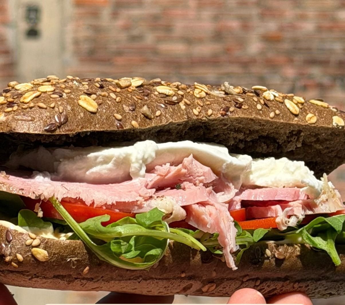 Lo chef Stefano Bona prepara un panino con il prosciutto cotto artigianale per i catering di Posto a Tavola